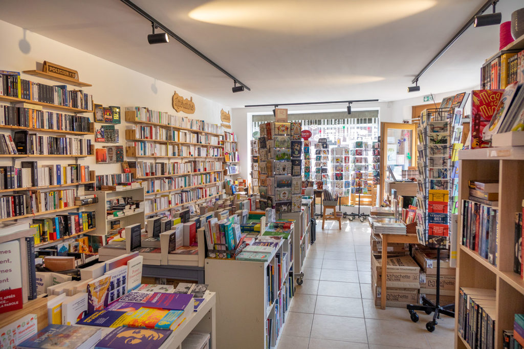 Autre vue de l'intérieur de la librairie Les Lisières à Ascq, avec les tourniquets de cartes postales à l'entrée.
