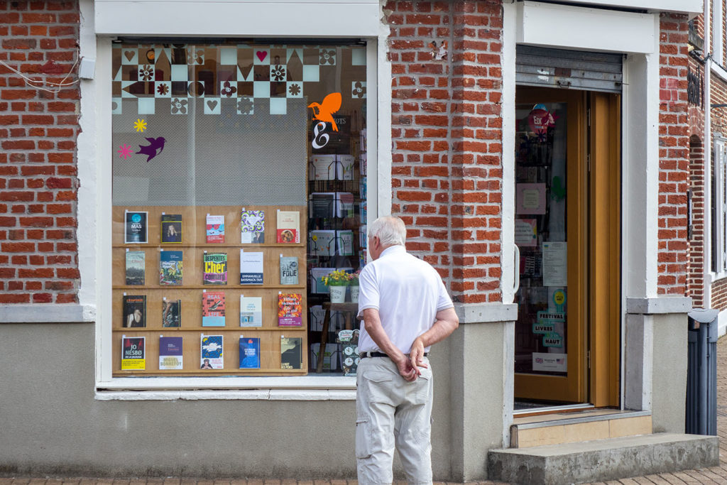Un passant s'arrête devant la vitrine de la librairie Les Lisières à Ascq.